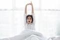 Asian woman Beautiful young smiling woman sitting and sleeping in white bed and stretching in the morning at bedroom after waking Royalty Free Stock Photo