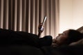 Asian woman on bed late at night and using mobile Royalty Free Stock Photo