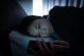 Asian woman on bed late at night and using mobile Royalty Free Stock Photo