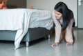 Asian woman bent and searching something under bed lost thing in bedroom Royalty Free Stock Photo