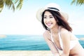 Asian woman with bikini and hat relaxing on the beach Royalty Free Stock Photo