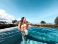 Asian woman in bikini in infinity swimming pool edge. luxury vacation near the sea. Royalty Free Stock Photo
