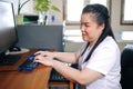 Asian woman with blindness disability using computer with refreshable braille display or braille terminal a technology assistive Royalty Free Stock Photo