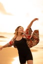 An Asian woman with blonde hair and a red shirt walks along the beach to enjoy the sea view Royalty Free Stock Photo