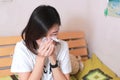 Asian woman blowing her nose while sitting on bed. illness woman Royalty Free Stock Photo