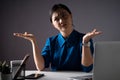 Asian woman in blue shirt feel confused, looking at copy space, working on a laptop at office.  on background Royalty Free Stock Photo