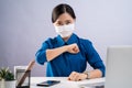 Asian woman in blue shirt wearing protective face mask confident put her fist on a left chest at office.  on white Royalty Free Stock Photo