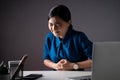 Asian woman in blue shirt was sick with stomach ache sitting at office. on white background