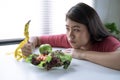 Asian woman is bored when she has to eat vegetables, She wants to eat delicious food, She is losing weight, Healthy eating ideas Royalty Free Stock Photo