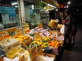 Asian woman buying some food from vendor in the market at night