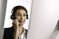 Asian woman call centre working use headset look at computer screen. Portrait of smiling Asian female customer service agent Royalty Free Stock Photo