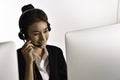 Asian woman call centre working use headset look at computer screen Royalty Free Stock Photo