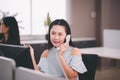 Asian woman callcenter talking on landline phone in modern office