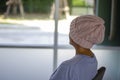 Asian woman with cancer, sitting with her back turned and looking out the window Royalty Free Stock Photo