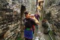 Asian woman carries baby behind the back in rural China.