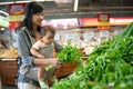 Asian woman carrying her baby while shopping Royalty Free Stock Photo