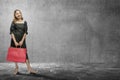 Asian woman carrying a shopping bag with a black wall background Royalty Free Stock Photo