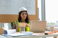 Asian woman of charming motivated middle aged industrial female engineer working and tablet in the workshop and blueprint on