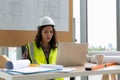 Asian woman of charming motivated middle aged industrial female engineer working and tablet in the workshop and blueprint on