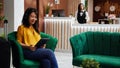 Asian woman checking webpages on tablet in hotel lobby