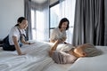 Asian woman and child girl visiting and consoling elderly grandmother lying in bed at home,adult daughter holding hands senior Royalty Free Stock Photo