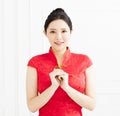 Woman in chinese cheongsam with congratulation gesture