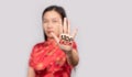 Asian woman in Chinese costume doing stop gesture with palm hand with message stop racism. warning expression