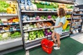 Asian woman choosing for purchase vegetables at the supermarket. Organic vegetarian food concept Royalty Free Stock Photo