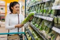 Asian woman choosing vegetables while shopping food in supermarket Royalty Free Stock Photo