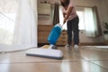 Asian woman cleaning the floor with vacuum cleaner in the living room. Royalty Free Stock Photo
