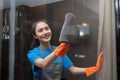 Asian woman cleaning the glass in the apartment. Cleaning staff maintain cleanliness in with towel and spray detergent