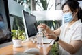 Asian woman cleaning hands with hand sanitizer after use and before starting work on computer at office,avoid contaminating with Royalty Free Stock Photo