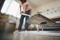 Asian woman cleaning and mopping the floor with a microfiber wet mop pad in the living room. Woman doing chores at home. Royalty Free Stock Photo