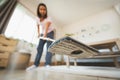 Asian woman cleaning and mopping the floor with a microfiber wet mop pad in the living room. Woman doing chores at home. Royalty Free Stock Photo