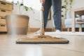 Asian woman cleaning and mopping the floor with a microfiber wet mop pad in the living room. Woman doing chores at home. Royalty Free Stock Photo