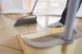 Asian woman cleaning and sweeping dust the floor with a broom in the living room. Woman doing chores at home. Royalty Free Stock Photo