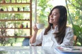 Asian woman close her eyes and listening to music with headphone while drinking coffee with feeling happy and relax in cafe with g Royalty Free Stock Photo