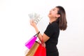 Asian woman with colorful shopping bags. One hand holds money one hundred dollar bill on white background.