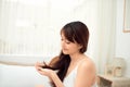 Asian woman combing her hair with anxiety