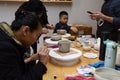 An Asian woman is concentrating on making pottery