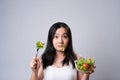 Asian woman confused with eating salad isolated over white background