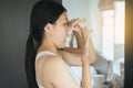 Asian woman covering her mouth and smell her breath with hands upter wake up,Bad smell