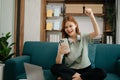 Asian business woman are delighted and happy with the work they do on their tablet, laptop and taking notes sofa at home Royalty Free Stock Photo