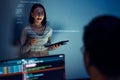 asian woman developers collaborating on a coding project, with one member presentation at code projected on the wall while the Royalty Free Stock Photo