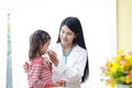 An Asian woman doctor examined a fever for a little girl in the hospital.
