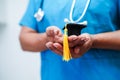 Asian woman doctor holding graduation hat in hospital, Medical education concept
