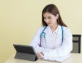 Asian woman doctor searching information about patient on her tablet Royalty Free Stock Photo