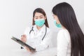 An Asian woman doctor is talking to a female patient about his pain and symptoms in the hospital Royalty Free Stock Photo