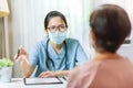 Asian Woman Doctor talking to female patient at the hospital