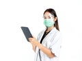 Asian woman doctor wearing green medical face mask, face shield and white coat with stethoscope. Portrait of young attractive Royalty Free Stock Photo